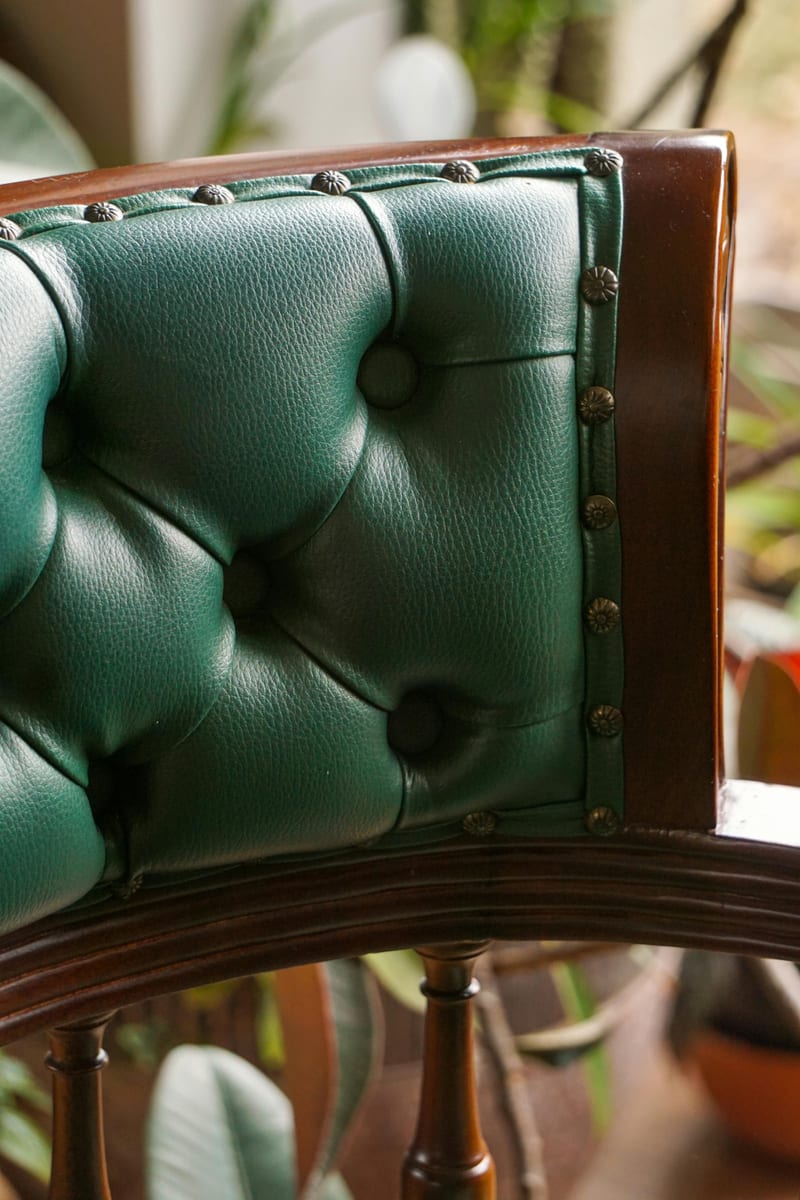 Detalle de tapizado capitoné en cuero verde artesanal