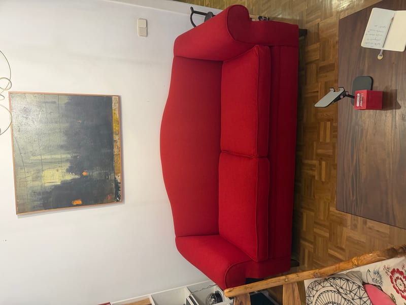 Tapizado de sofá rojo de tres plazas en taller de Madrid